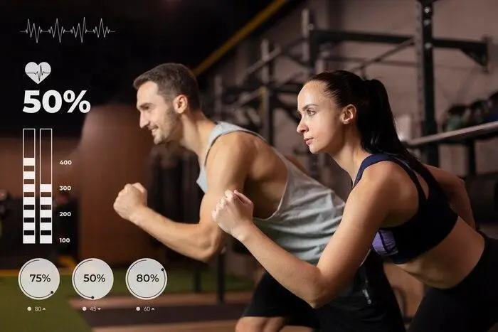 Man and woman exercising in gym with heart rate data display in background