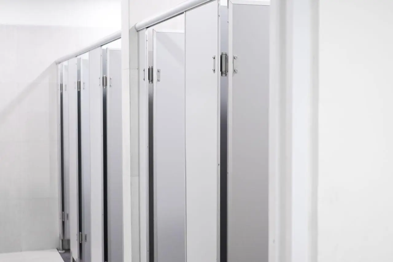 White restroom stalls in a clean, bright public bathroom setting