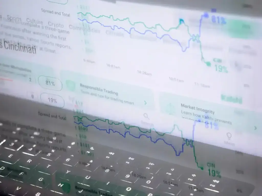 Stock market graphs reflected on a laptop keyboard in soft lighting environment