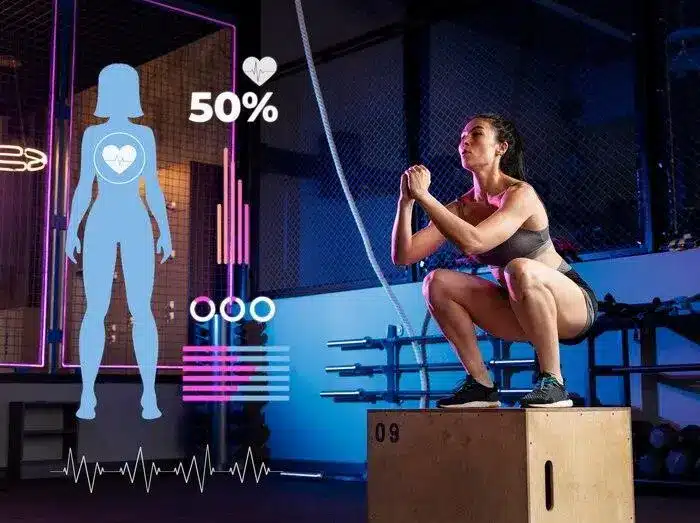 Woman performing box squats in gym with digital health stats overlay in low light setting
